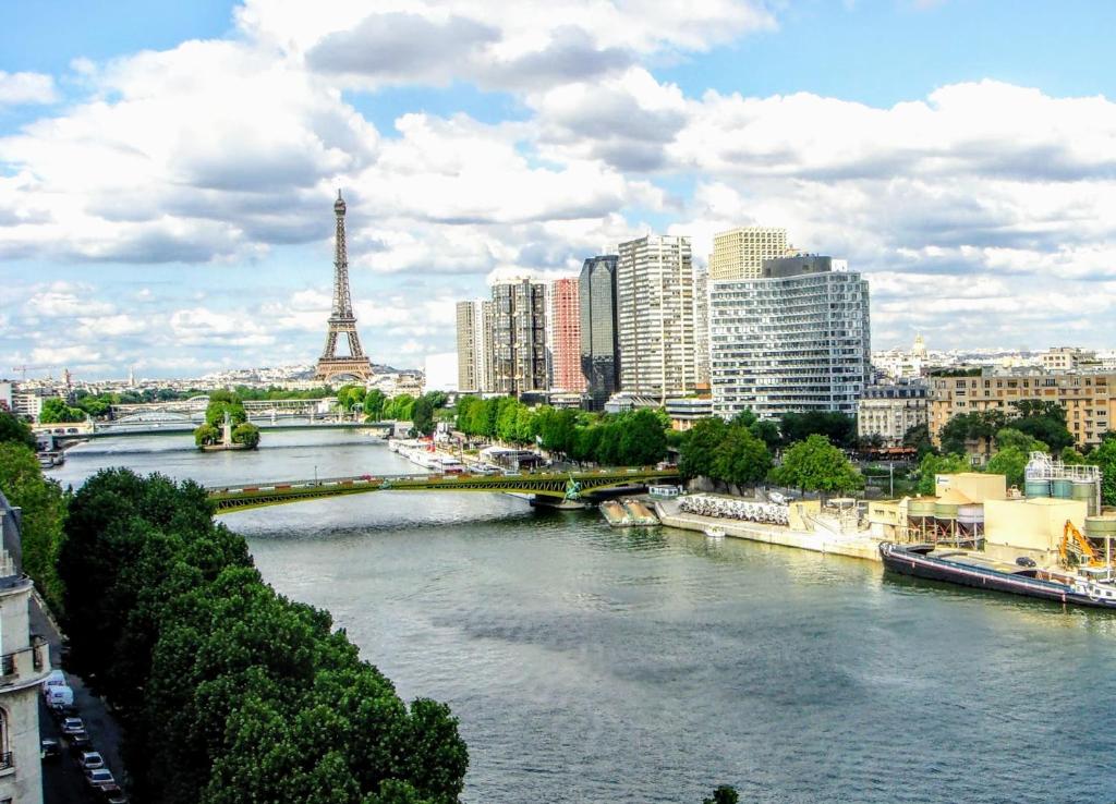 un río en una ciudad con un puente y la torre Eiffel en EIFFEL TOWER PENTHOUSE, en París