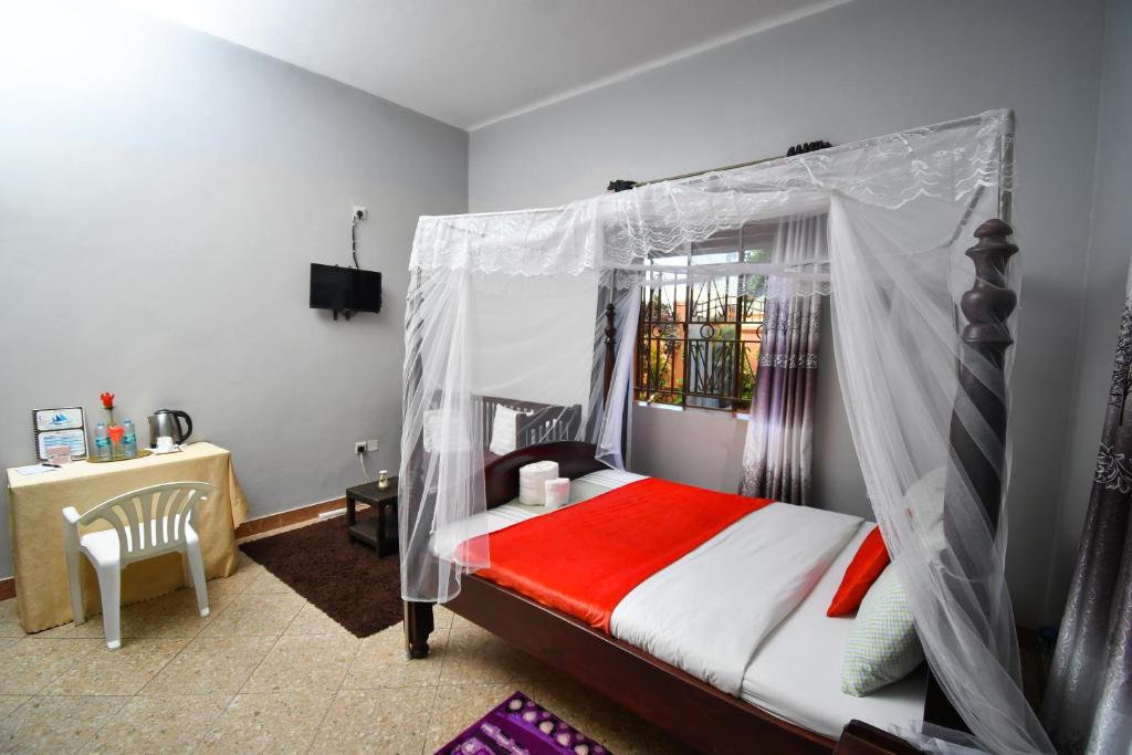 מיטה או מיטות בחדר ב-Jinja Grand Hotel