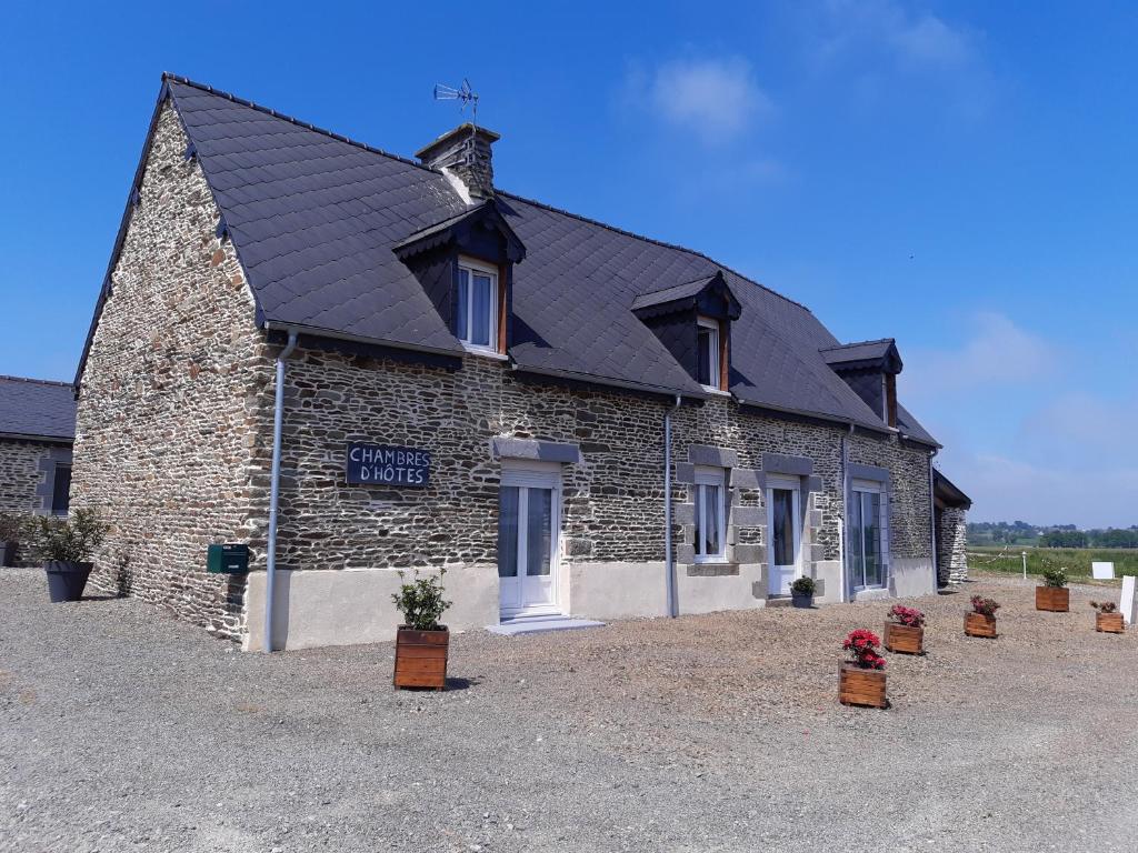 a brick building with potted plants in front of it at Les escargots du mont in Tanis