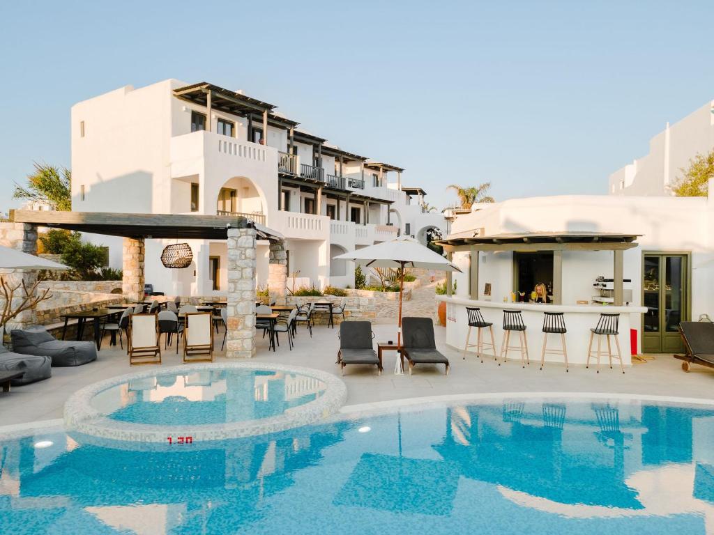 a pool at a hotel with chairs and tables at Melidron Hotel & Suites in Agios Prokopios