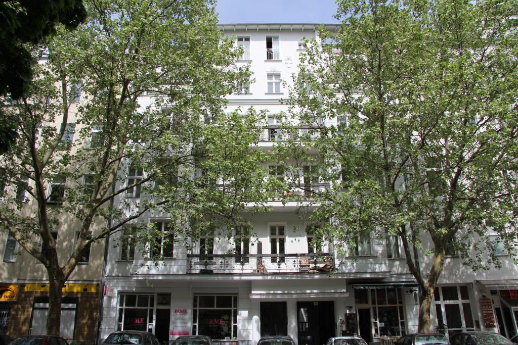 un edificio blanco con árboles delante de él en Nollendorf Apartments, en Berlín