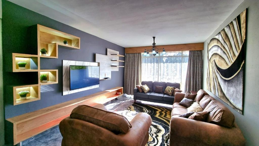 クルーガーズドープにあるAffordable Hyswan Family Guesthouseのリビングルーム(ソファ2台、テレビ付)