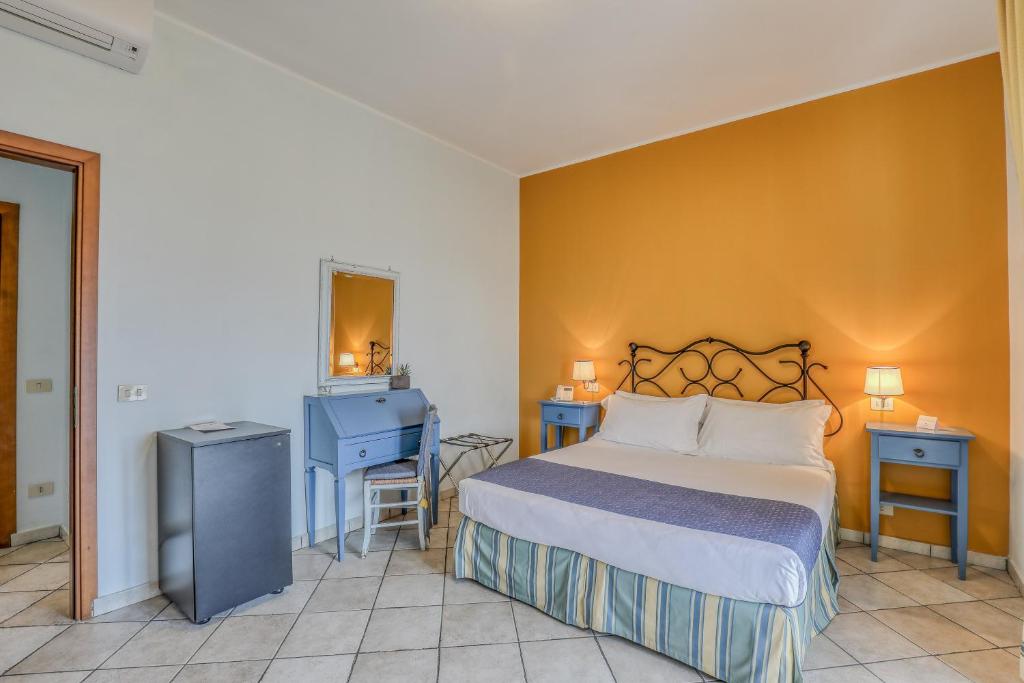a bedroom with a bed and a desk and a mirror at Hotel Albatros Varigotti in Varigotti