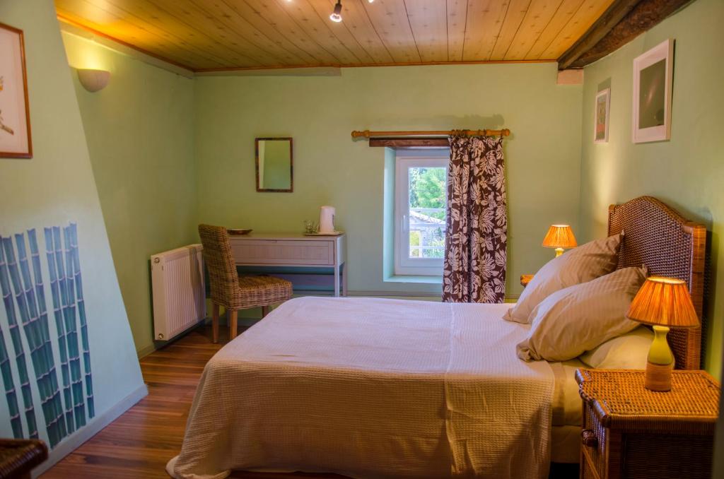a bedroom with a bed and a desk and a window at La Pause Céleste in Ordonnac