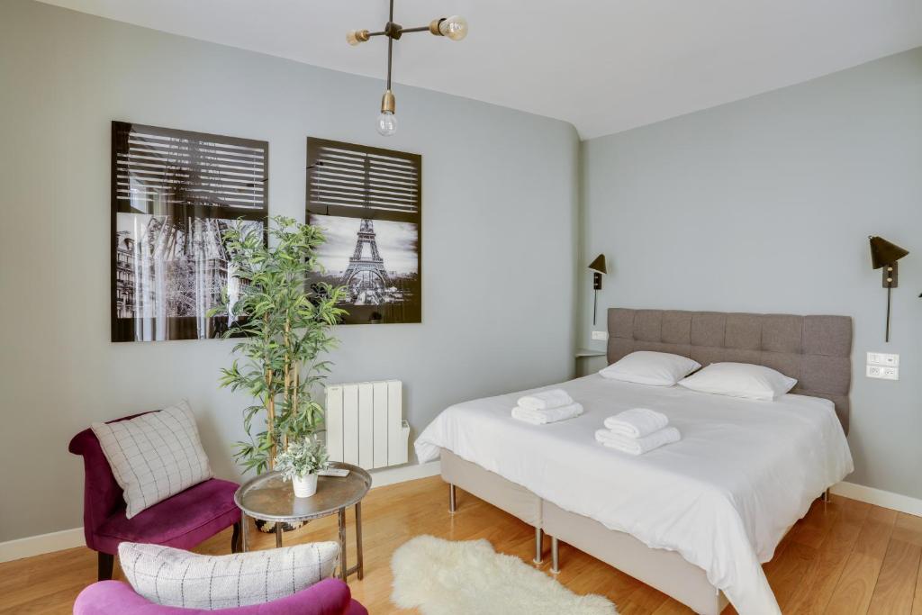 une chambre avec un lit, une table et des chaises dans l'établissement Charmant studio au coeur de Paris pour 2 personnes by Weekome, à Paris