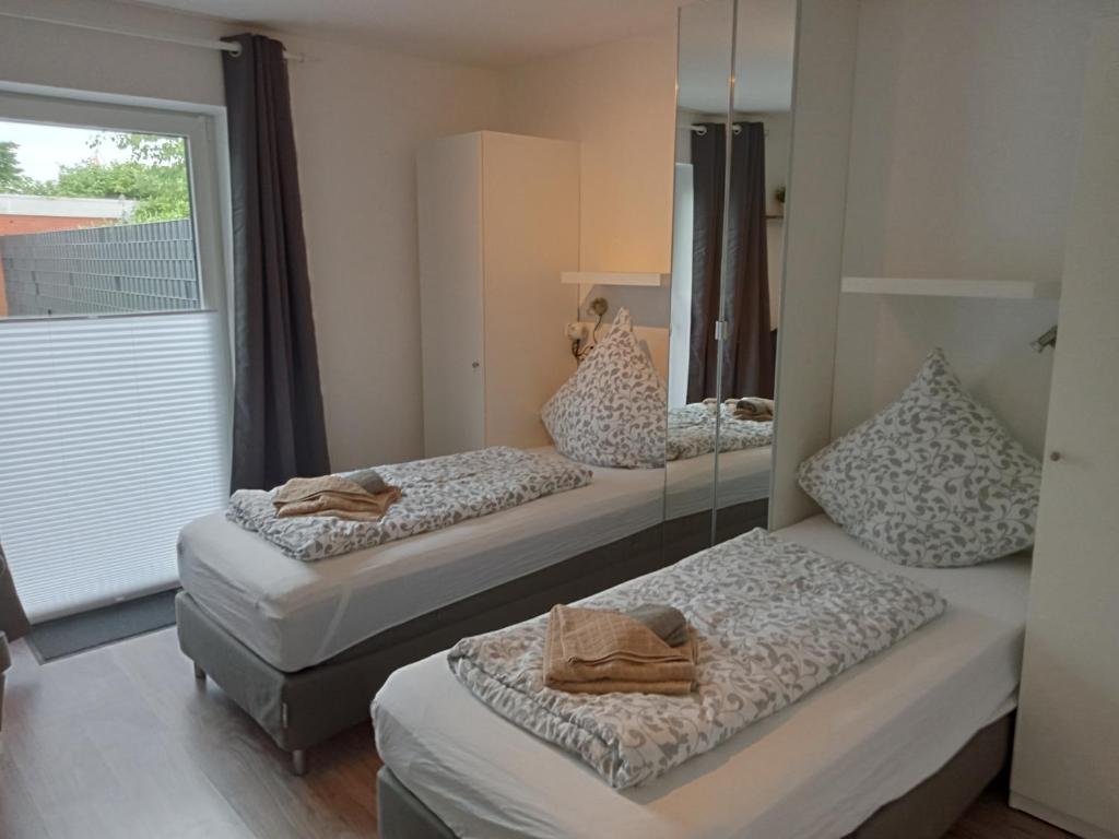 2 camas en una habitación con ventana en Ferienhaus am Binnenhafen, en Emden