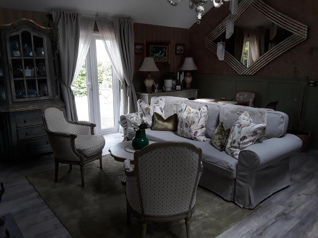 a living room with a white couch and chairs at Ballybur Lodge Mews 1 in Kilkenny