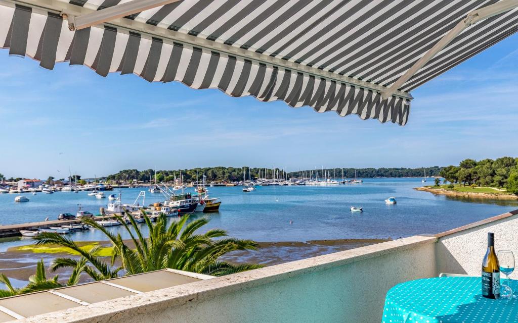 - une vue sur le port de plaisance avec une table et un parasol dans l'établissement Marija Marković Medulin A10, à Medulin