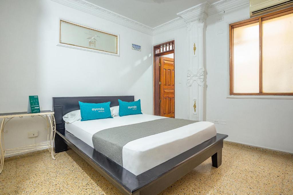 a bedroom with a large bed with blue pillows at Ayenda William Sanchez in Apartadó