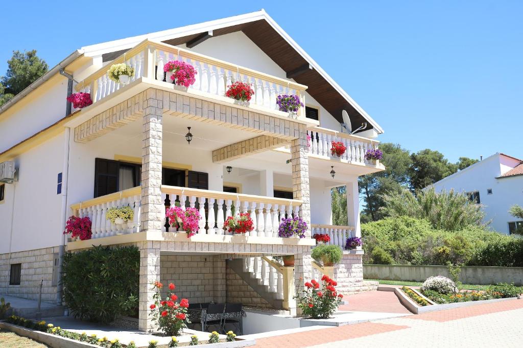 a house with flowers on the balconies at Apartmani Bruno in Bibinje