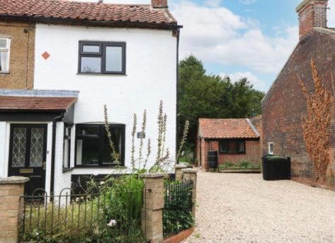 una casa blanca con una valla delante en Lavender Cottage en Mattishall