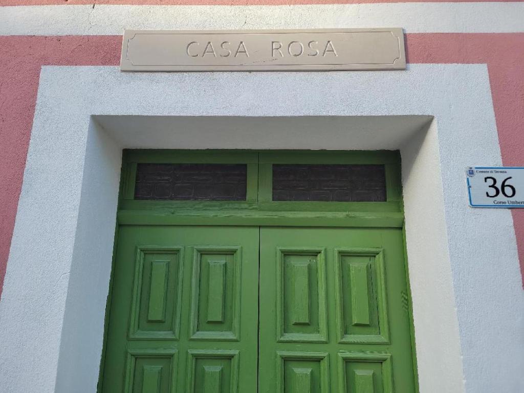 une porte verte sur un bâtiment avec un panneau au-dessus de celui-ci dans l'établissement Ancient Stone 'Casa Rosa'- Sea and Mountain View Tranquil Borgo, à Tavenna