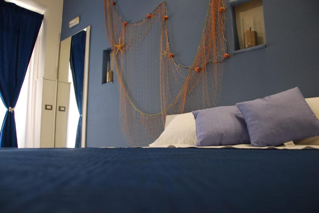 a bedroom with a bed with blue walls at Four Seasons Summer Room in Cefalù