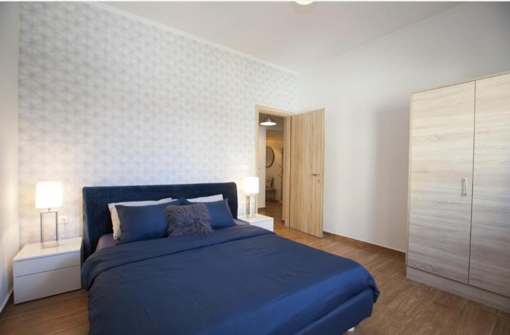 sypialnia z niebieskim łóżkiem i białą ścianą w obiekcie Great Living w mieście Rodos