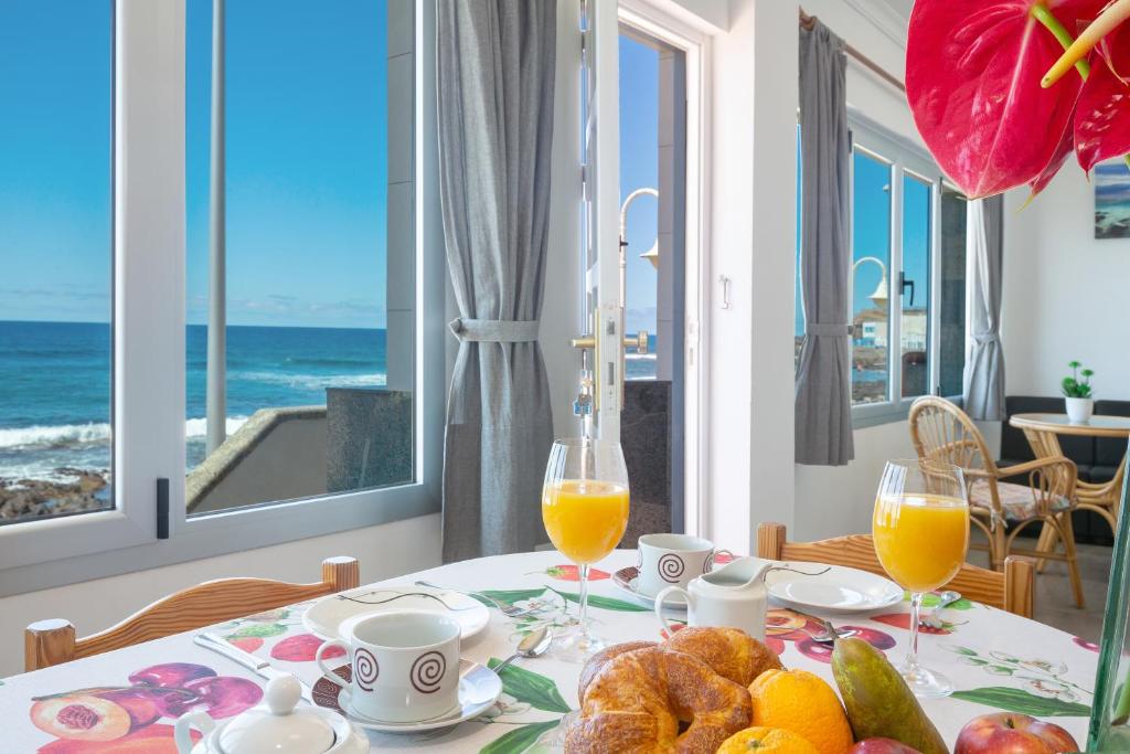 einen Tisch mit einem Teller Essen und zwei Gläsern Orangensaft in der Unterkunft Casa Avenida del Agujero in Gáldar