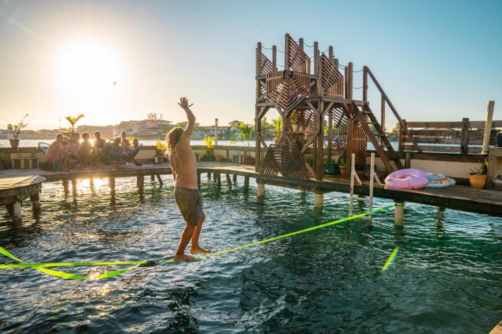 un homme debout sur une planche dans une piscine dans l'établissement Aqua Lounge Bar & Hostal, à Bocas del Toro