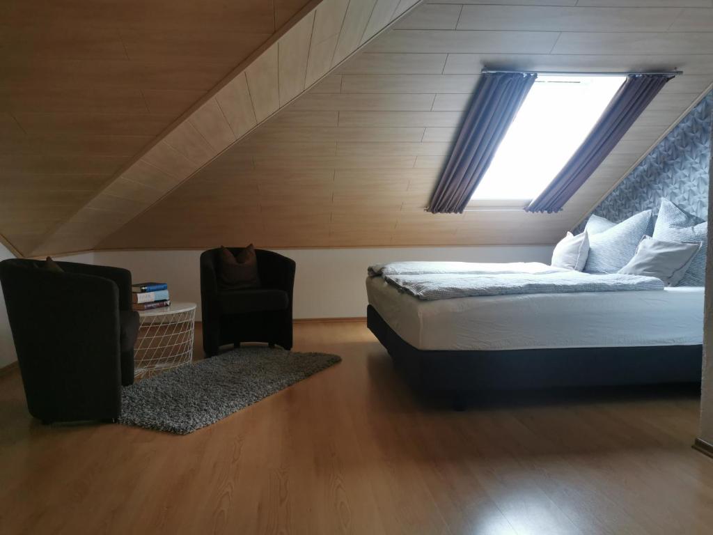 een slaapkamer met een bed, een raam en een stoel bij Apartment Hasselstrasse in Mehren