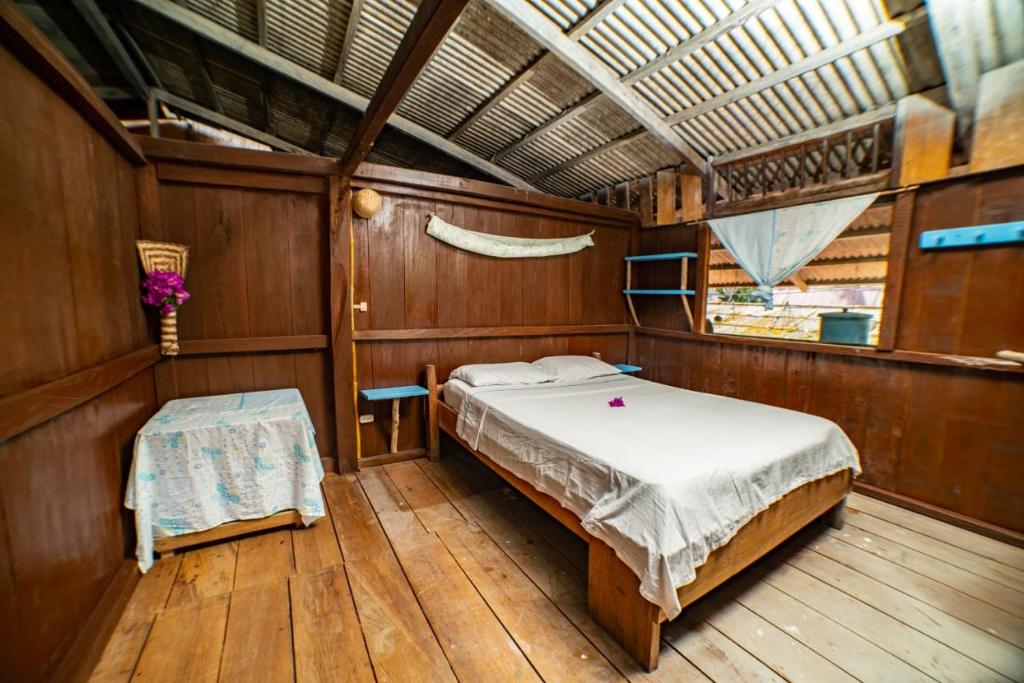 um quarto com uma cama e uma mesa num barco em Posada El Esfuerzo em Nuquí