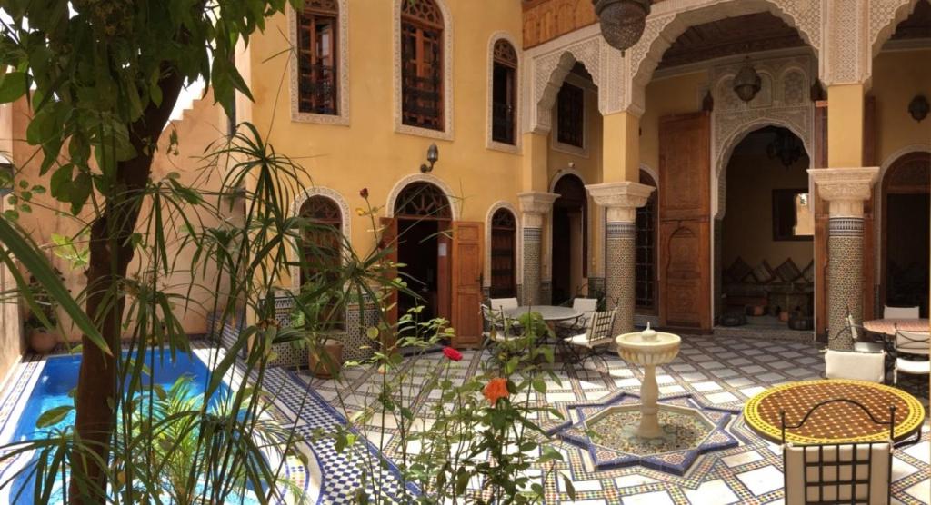 a courtyard with tables and chairs in a building at Riad Layalina Fes in Fès