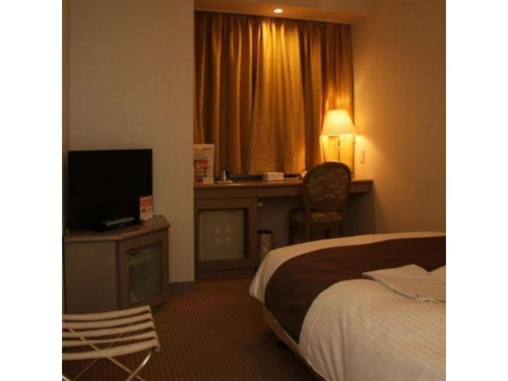Habitación de hotel con cama y TV en Kitami Pierson Hotel - Vacation STAY 54802v, en Kitami