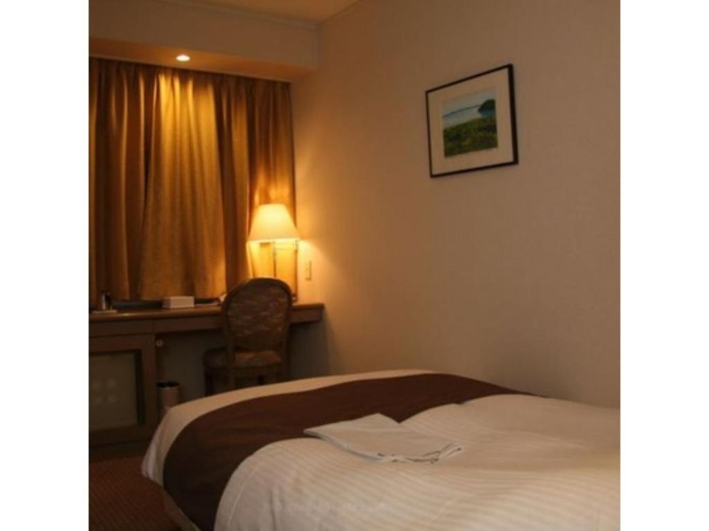 北见Kitami Pierson Hotel - Vacation STAY 54782v的配有一张床、一张书桌和一扇窗户的酒店客房