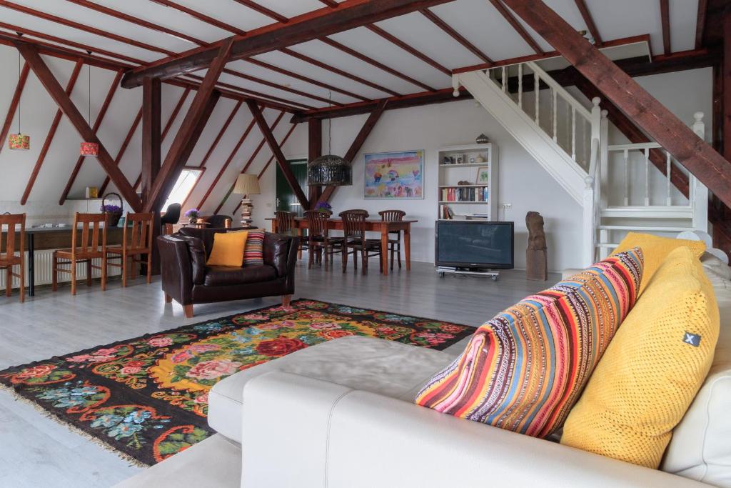 - un salon avec un canapé et une salle à manger dans l'établissement Het Grote Paard, à Havelte