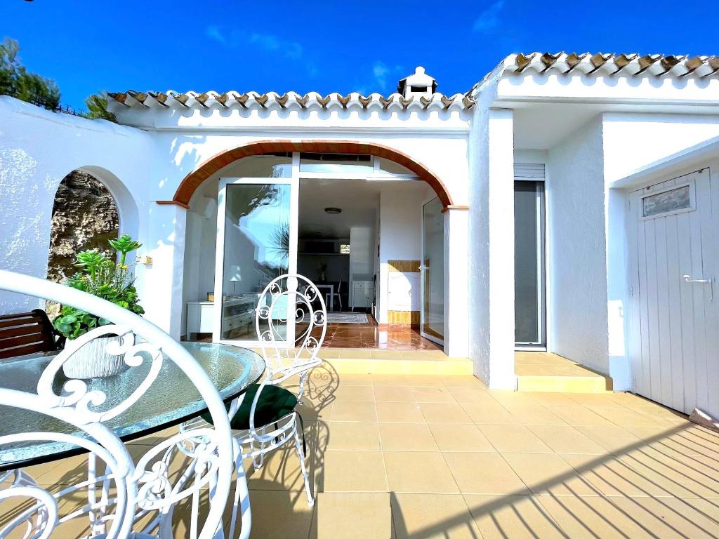 eine Terrasse mit einem Tisch und Stühlen auf einem Haus in der Unterkunft Hill Top House Mountain Views Moraira in Moraira