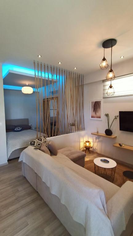 a bedroom with a large bed and a living room at Sea & Sun cozy studio in Kremasti