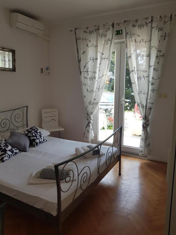a bedroom with a bed and a large glass door at Apartments Joko in Omiš