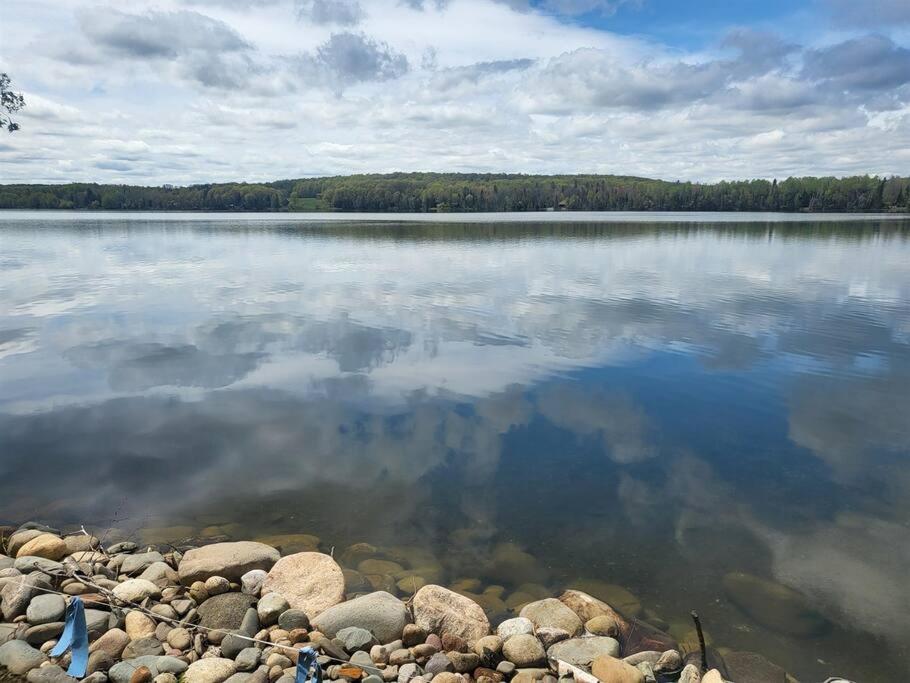 a large lake with rocks in the water at Crescent Lakehouse - Surf, Ski and Serenity in Iron River