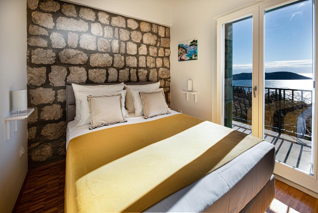 ein Schlafzimmer mit einem großen Bett und einer Steinmauer in der Unterkunft Ponte Apartment in Orasac