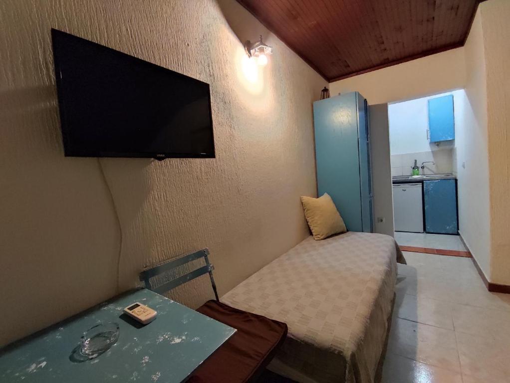 um pequeno quarto com uma cama e uma televisão de ecrã plano em Vojinovic Apartments em Budva