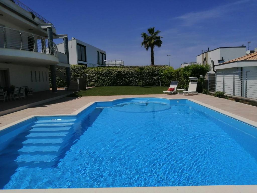 a large blue swimming pool next to a house at just blue in Montesilvano