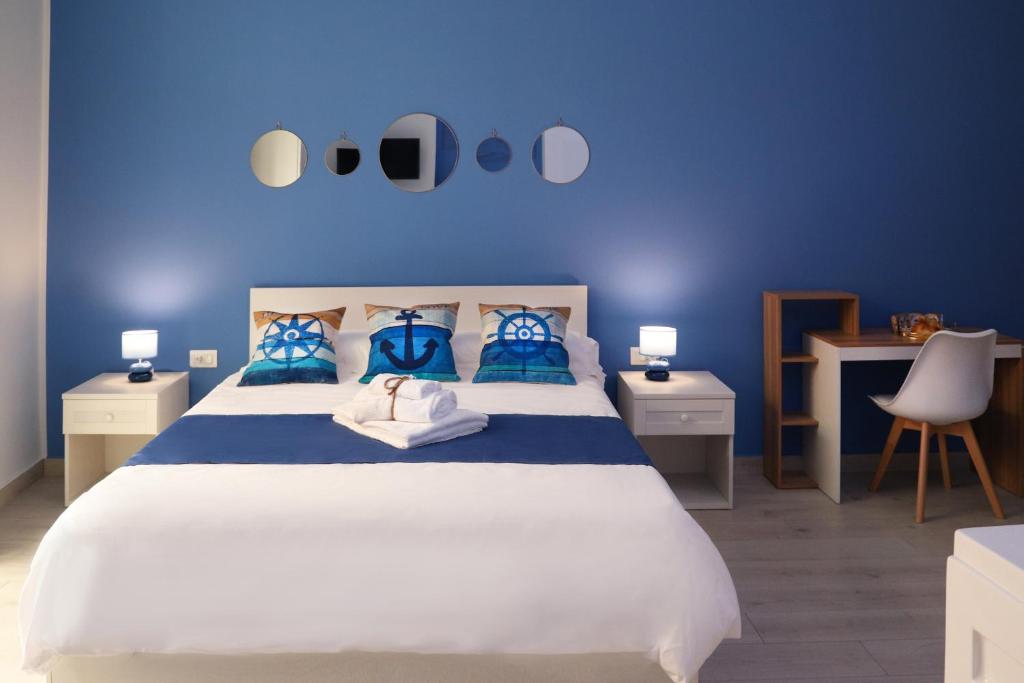 ein Schlafzimmer mit einem großen weißen Bett mit blauen Wänden in der Unterkunft Ancora B&B in Castellammare di Stabia