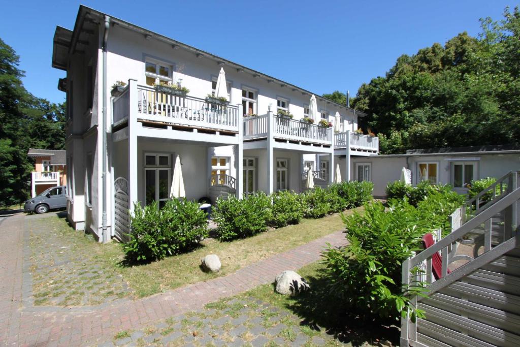 Großes weißes Haus mit Balkon und Büschen in der Unterkunft "Haus Rubert" 4 Sterne Fewos, strandnah in Zinnowitz