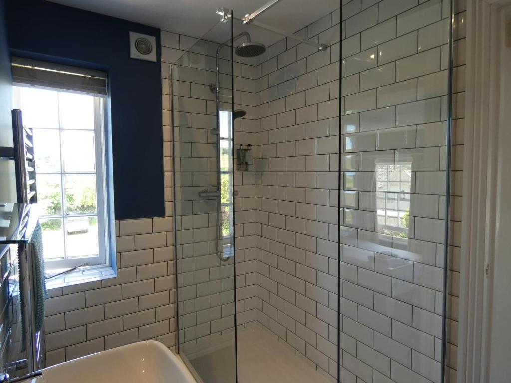 a bathroom with a glass shower with a sink at The Sloop Inn in Kingsbridge