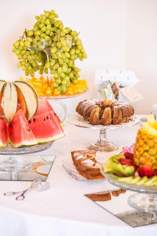 a table topped with plates of food and fruit at Hotel Albatros Varigotti in Varigotti