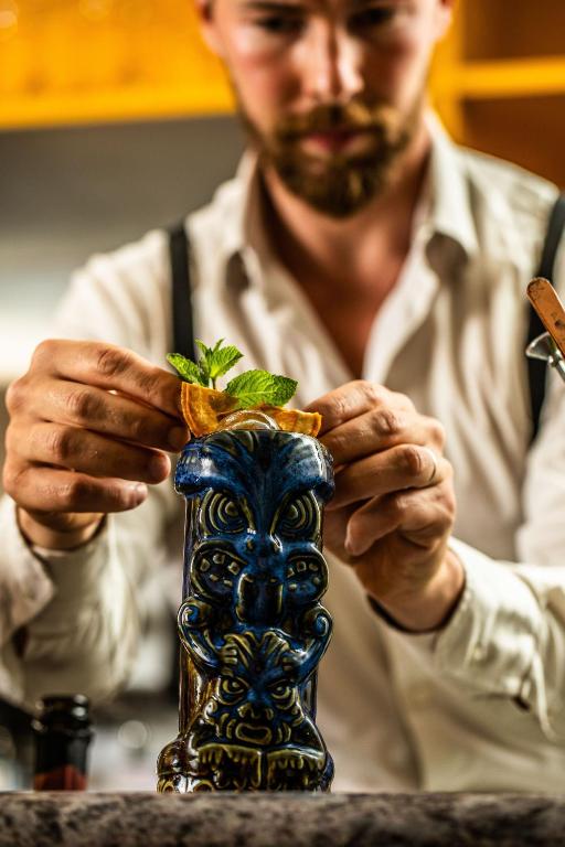 a man sitting at a table holding a blue vase at Hotel Albatros Varigotti in Varigotti