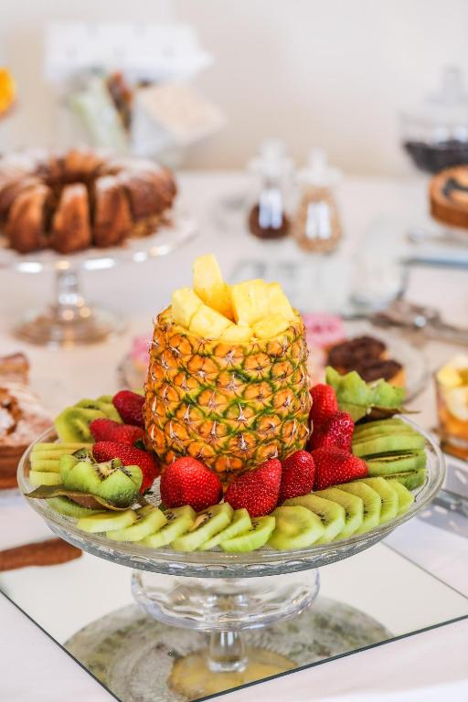 a plate with a pineapple and strawberries on a table at Hotel Albatros Varigotti in Varigotti