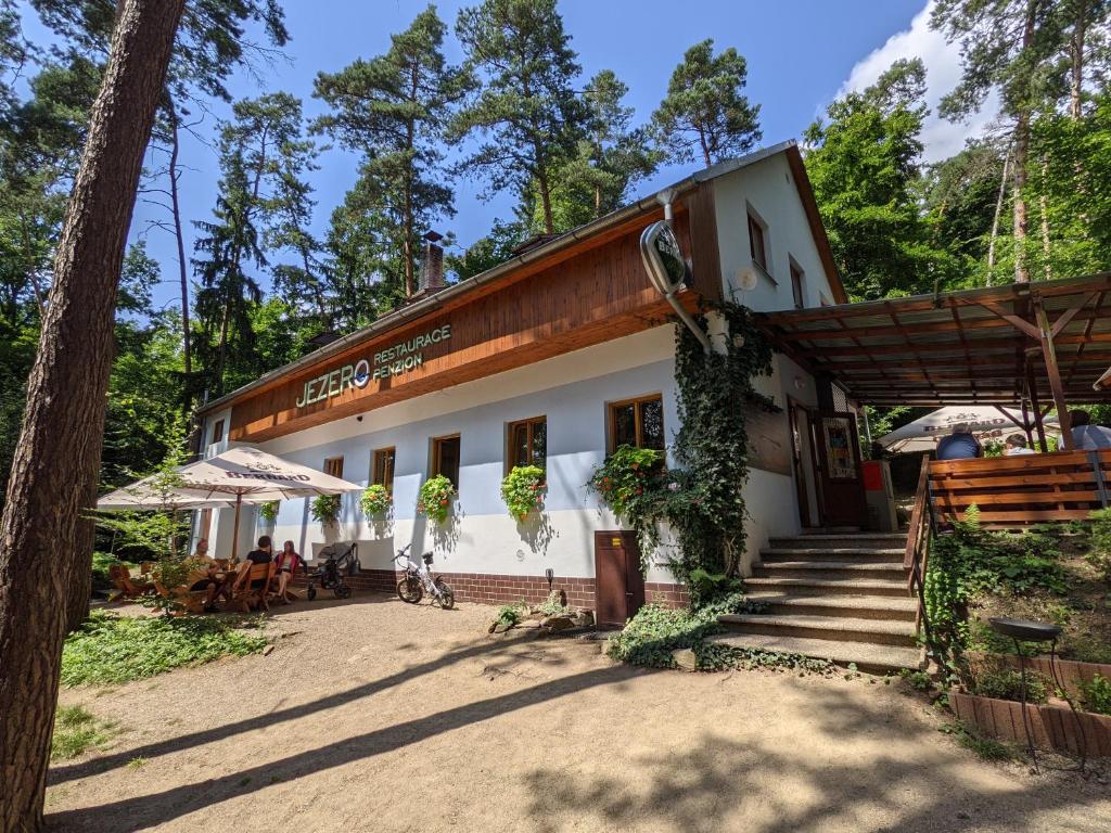a building with a porch and stairs in front of it at Penzion Jezero in Vranov nad Dyjí