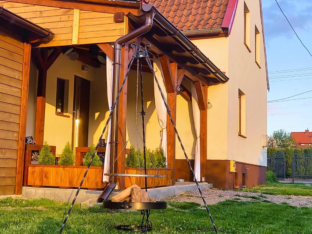 a house with a porch with a swing at Całoroczny dom w sercu Mazur in Węgorzewo