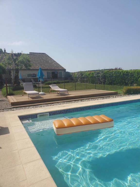 a swimming pool with two chaise lounges and a swimming pool at Gîte Le Pressoir in Cahuzac-sur-Vère