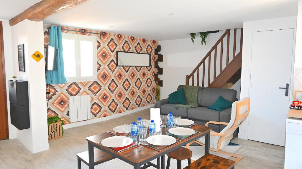 a living room with a table and a couch at TRAVEL Appartement 10mn Aeroport CDG in Villeneuve-sous-Dammartin