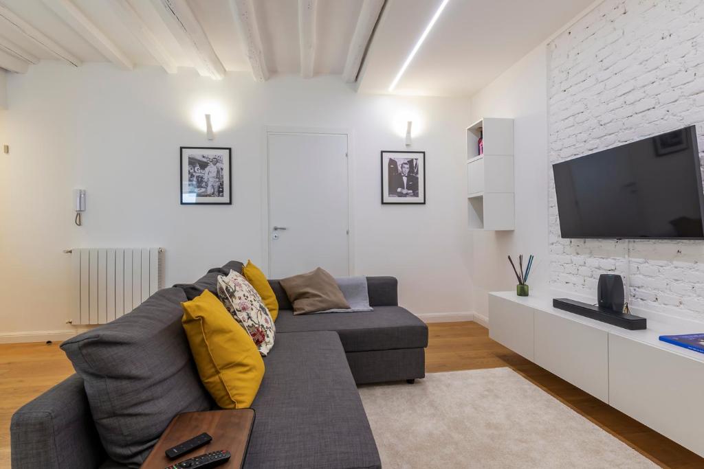 sala de estar con sofá gris y TV en Castaldi 18 - Milano in tasca en Milán