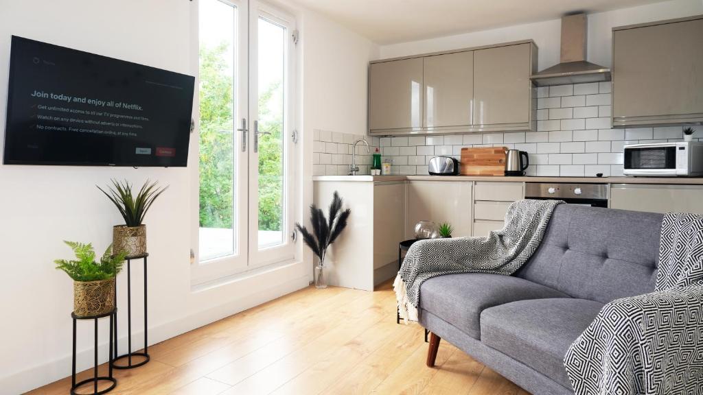 a living room with a couch and a kitchen at The Kop End Penthouse in Liverpool
