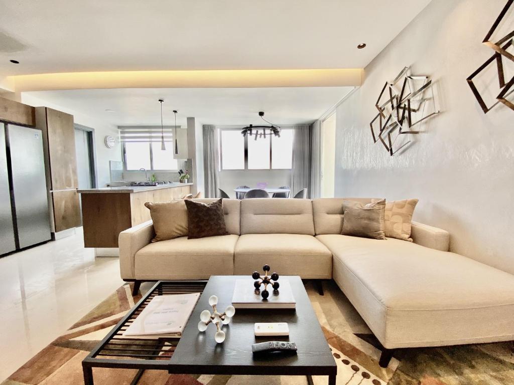 sala de estar con sofá y mesa en New Modern Lux City Condo With Pool And Gym Ocean View Santo Domingo, en Ciudad Nueva