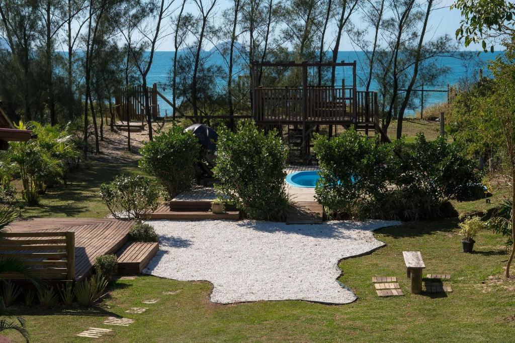 un patio trasero con piscina y parque infantil en Pousada Estação Sol e Lua, en Florianópolis