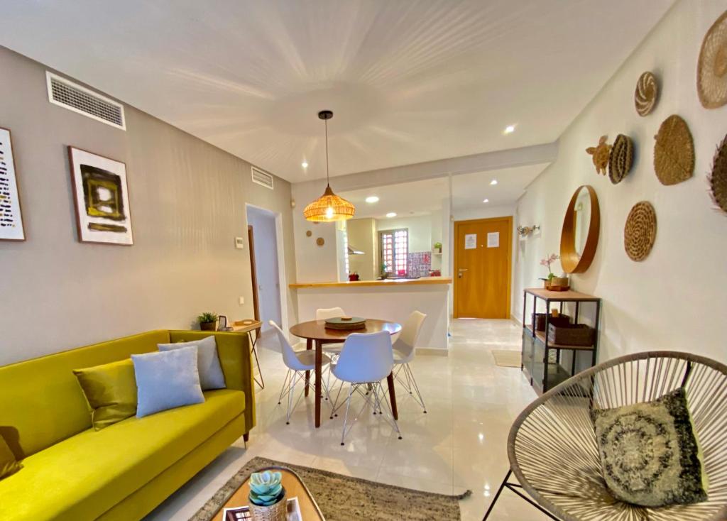 sala de estar con sofá amarillo y mesa en Resort Style 2 Bedroom Apartment in the New Golden Mile FREE WIFI & PARKING, en Estepona