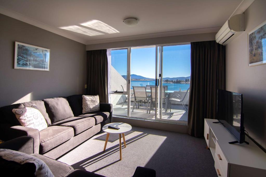 a living room with a couch and a television at Rydges Horizons Snowy Mountains in Jindabyne