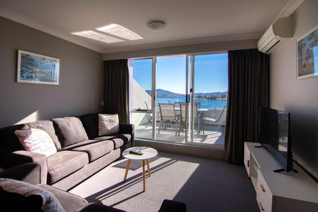 sala de estar con sofá y TV en Rydges Horizons Snowy Mountains, en Jindabyne